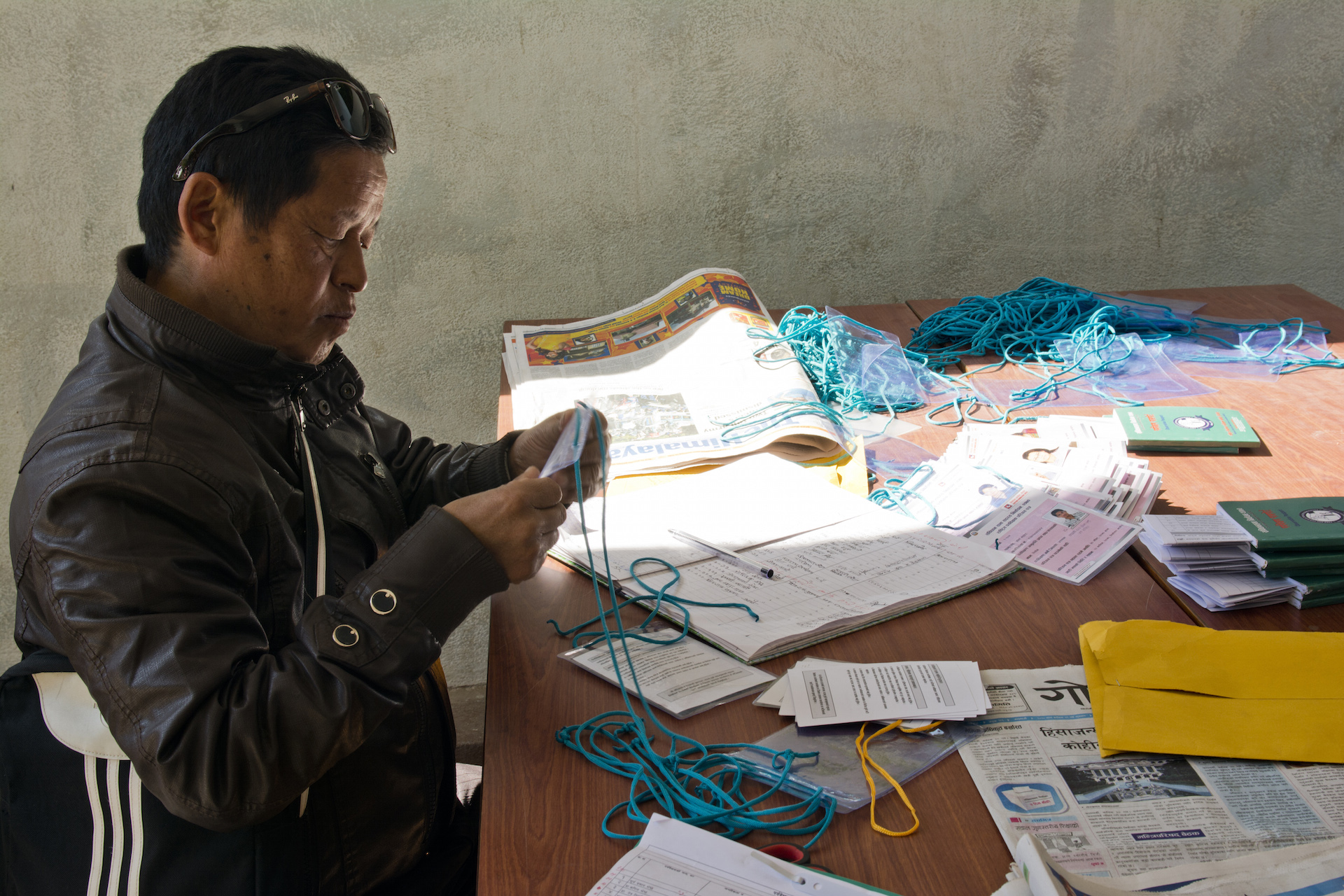 At the National Election Observation Committee, a domestic election observation organization based in Kathmandu, a worker hands out observer credentials.