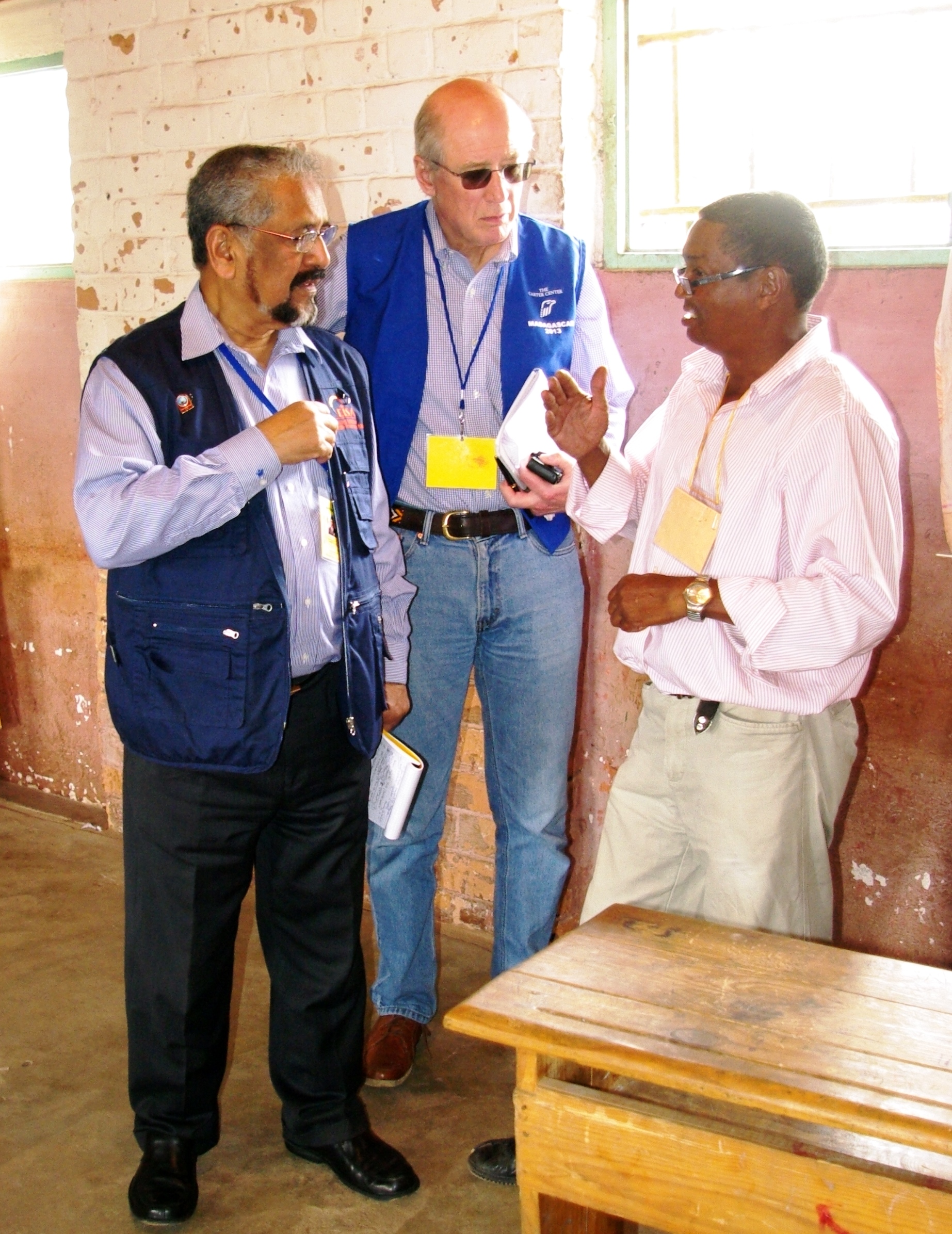 President Cassam Uteem, former president of Maritius (left), and Dr. John Stremlau of The Carter Center speak with polling station staff on election day.